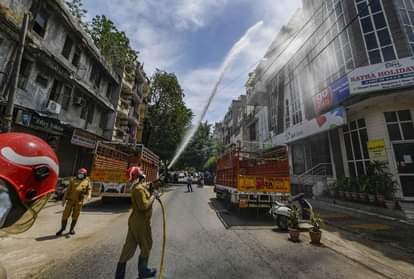 नई दिल्ली में निजामुद्दीन इलाके में लॉकडाउन के दौरान दवा का छिड़काव करता दमकल कर्मी।