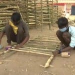 छत्तीसगढ़ के सूरजपुर जिले के एक राहत शिविर में बांस की बाड़ बनाते मजदूर