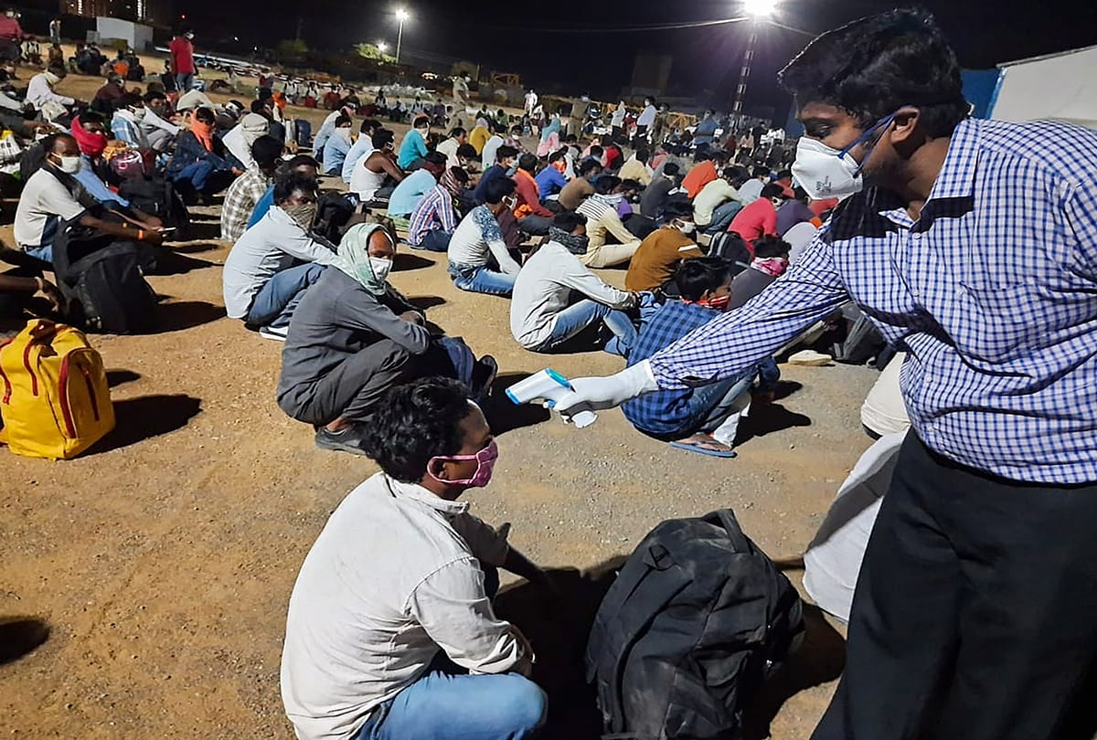 तापमान जांचता स्वास्थ्य कर्मचारी