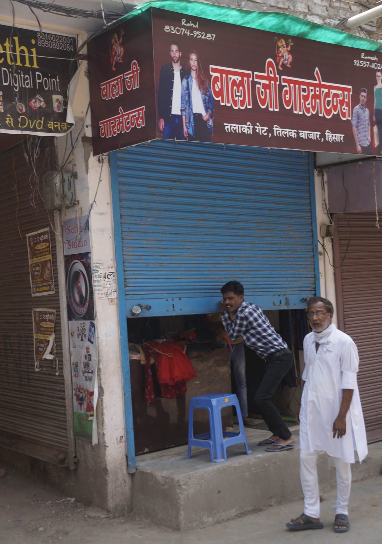 Waiting for customers outside the shop, saw the camera, dropped the shutter