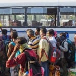 पटना में अपने घरों को जाने के लिए बस में सवार होते प्रवासी मजदूर।