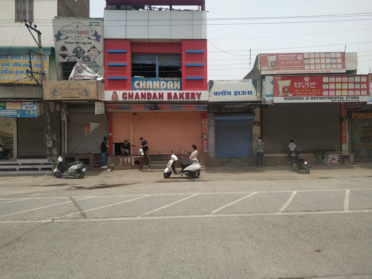 shopkeeper selling product by opening half shutter