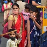 बंगलूरू में ट्रेन में सवार होने के लिए स्टेशन पहुंची महिला और बच्चे।