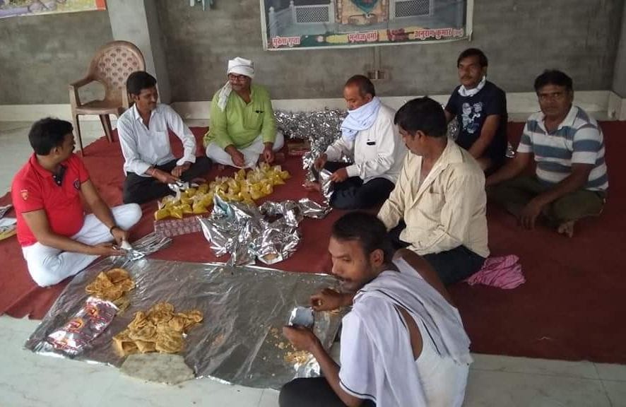 social worker giving food to needies in etawah