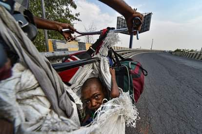 lockdown father carries his physically challenged girl sits on a makeshift seat of bicycle travel with family