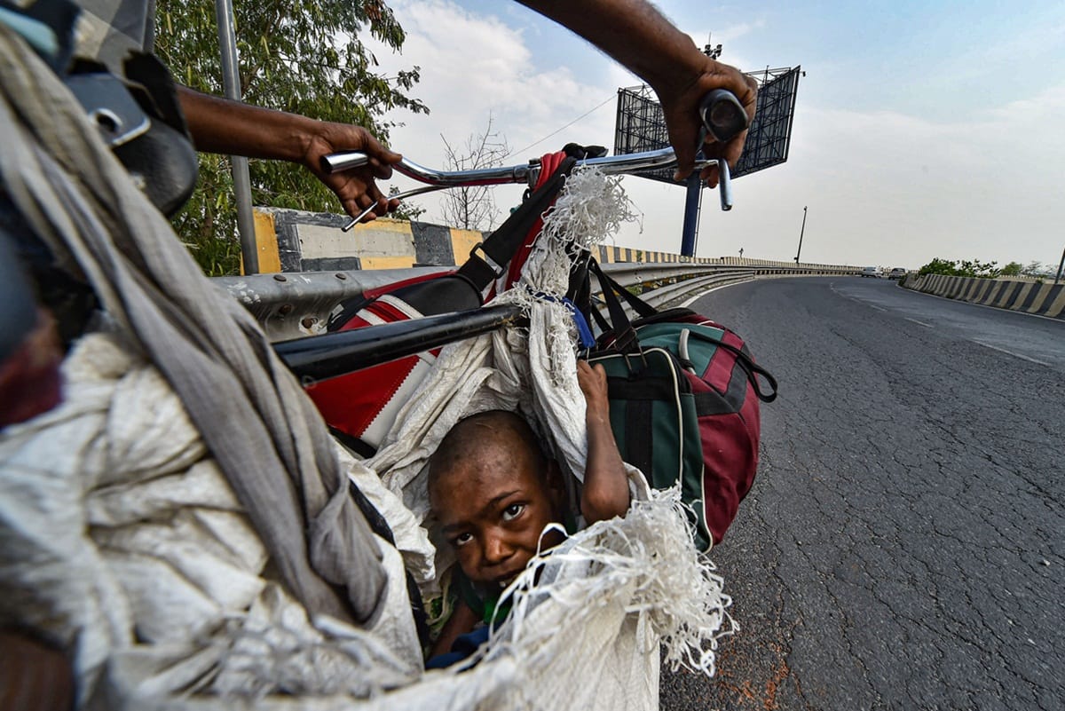 lockdown father carries his physically challenged girl sits on a makeshift seat of bicycle travel with family