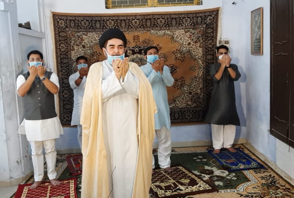 People offer prayer on Eid at their home.