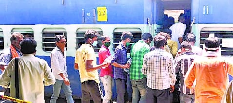 Workers snatch water bottles placed on the platform