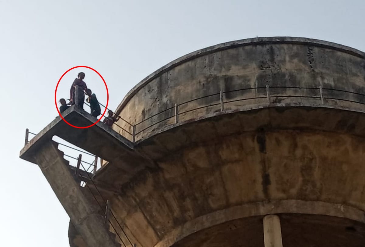 Woman climbing on water tank with two children in Gorakhpur