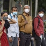 नई दिल्ली में बस का इंतजार करते लोग।