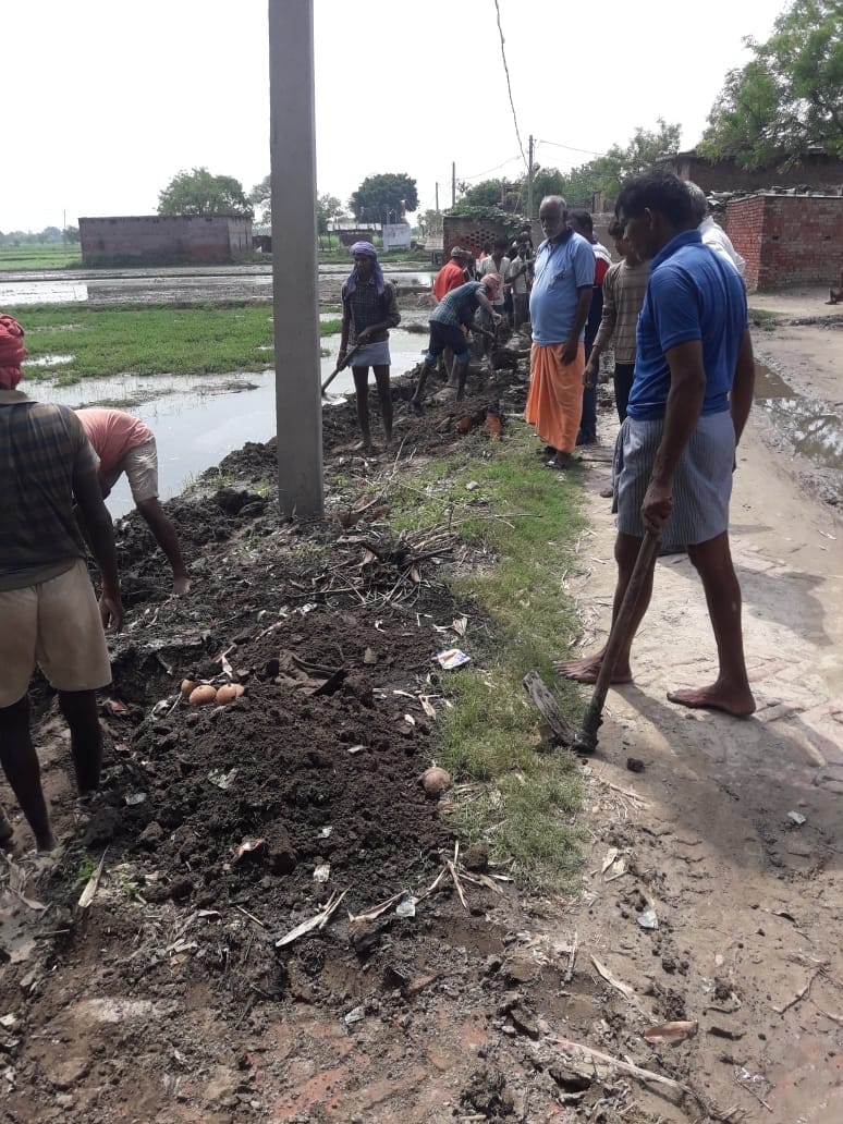 Villagers cleaning public drain, show mirror