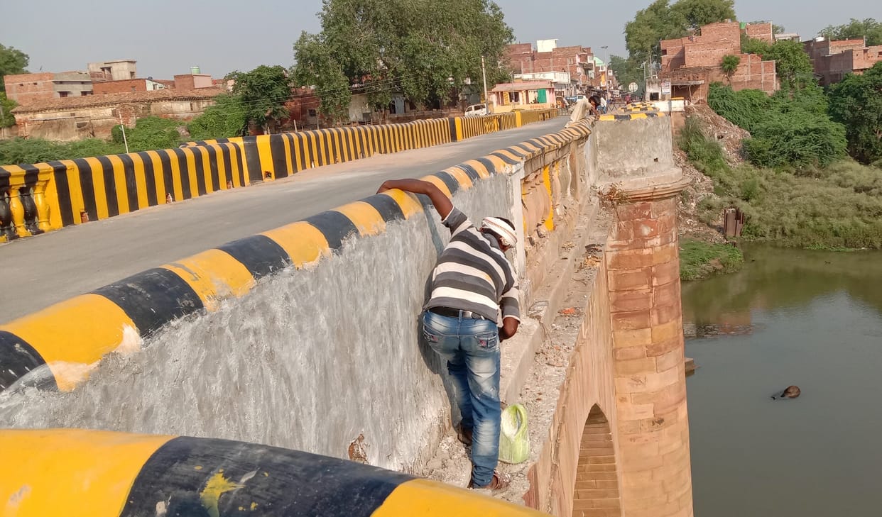 Laborers working on the bridge without safety belts and helmets