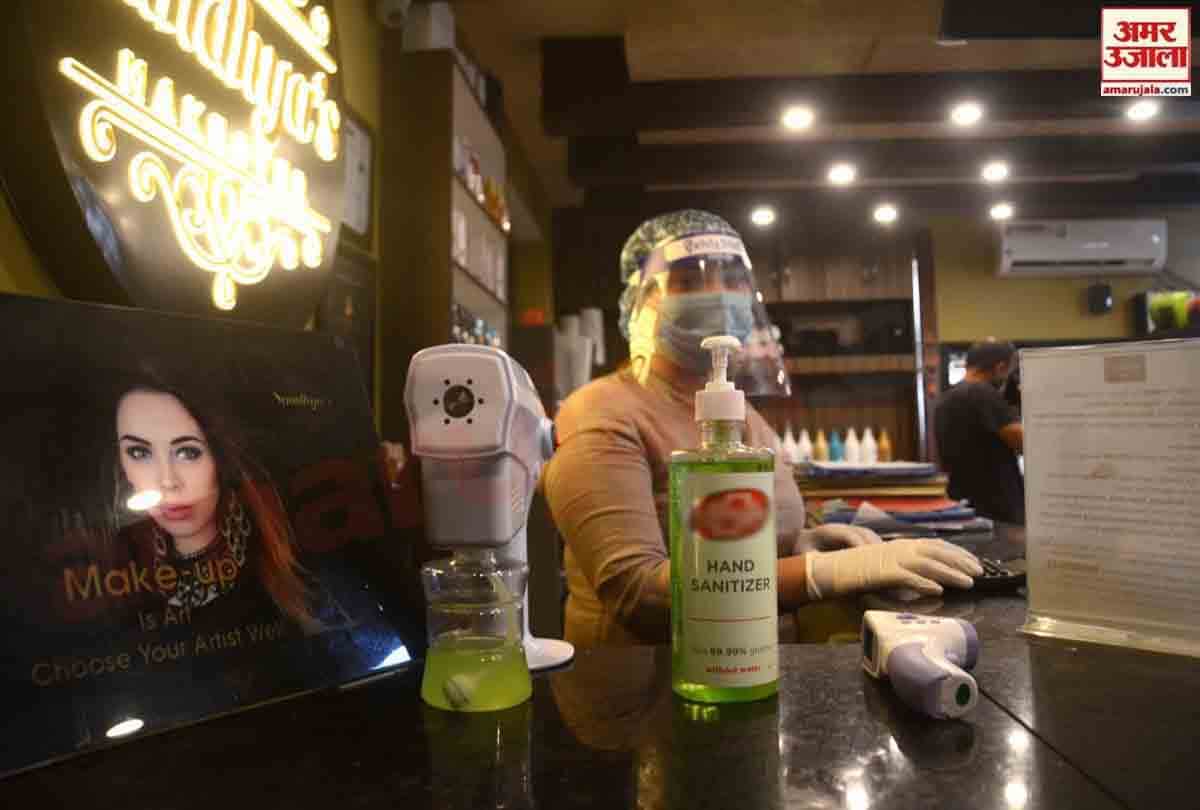 Hairdressers wearing personal protective equipment attend a customer at a hair salon