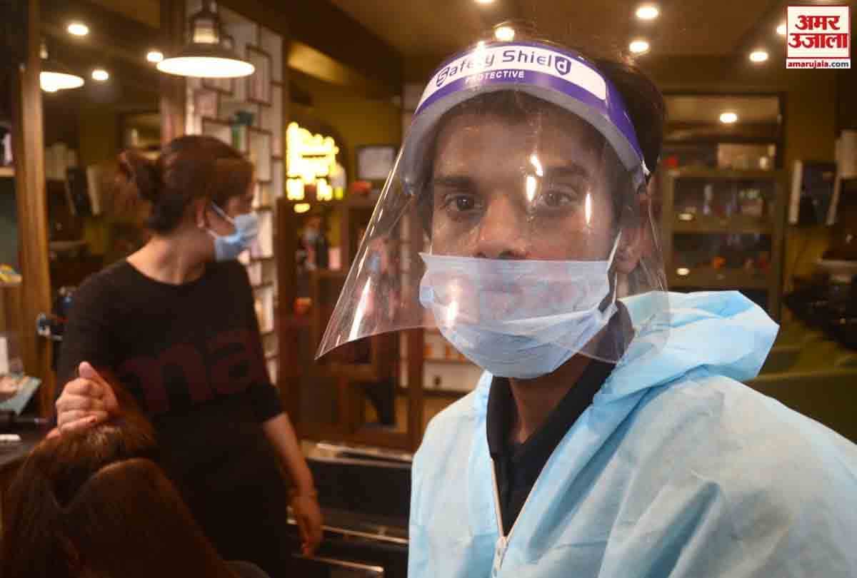 Hairdressers wearing personal protective equipment attend a customer at a hair salon