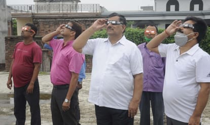 View of solar eclipse seen through filter glasses and telescopes