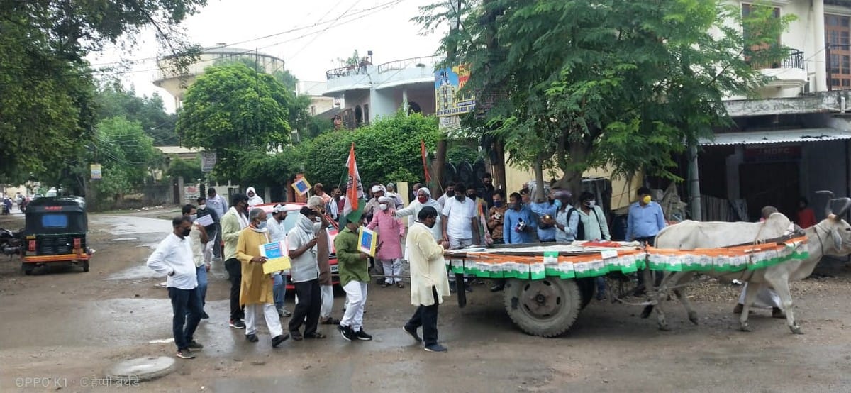 Congress workers pull car from bullock cart to protest petrol and diesel price hike in varanasi
