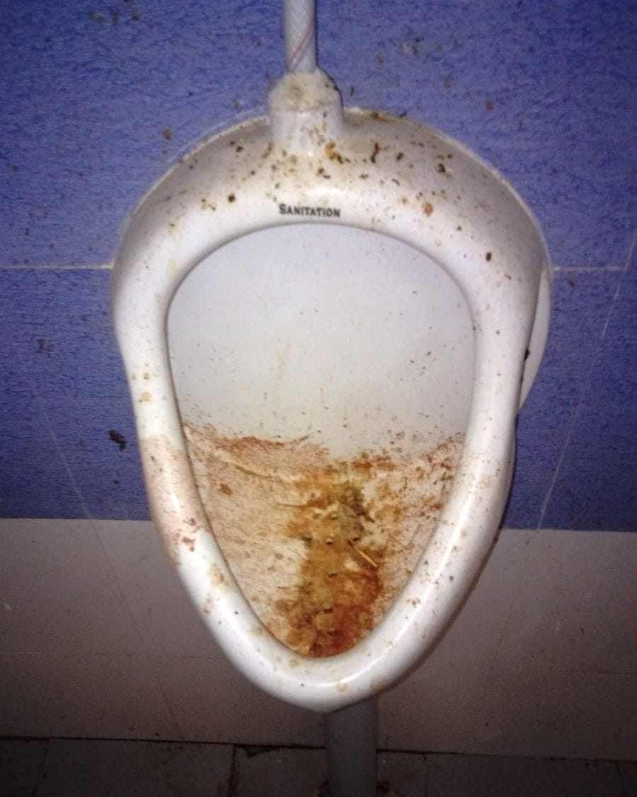 Toilet in staging area, dirt in urinal