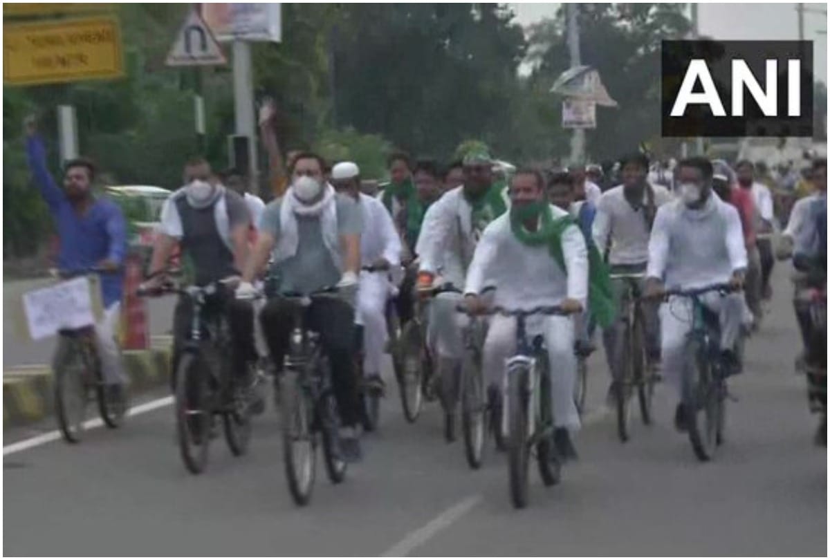 Tejashwi and Tej Pratap Yadav ride bicycles along with party supporters protest against the increase in fuel prices