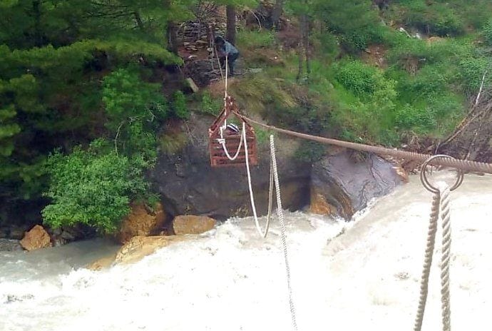 The film people are crossing the river with the help of rope trolley