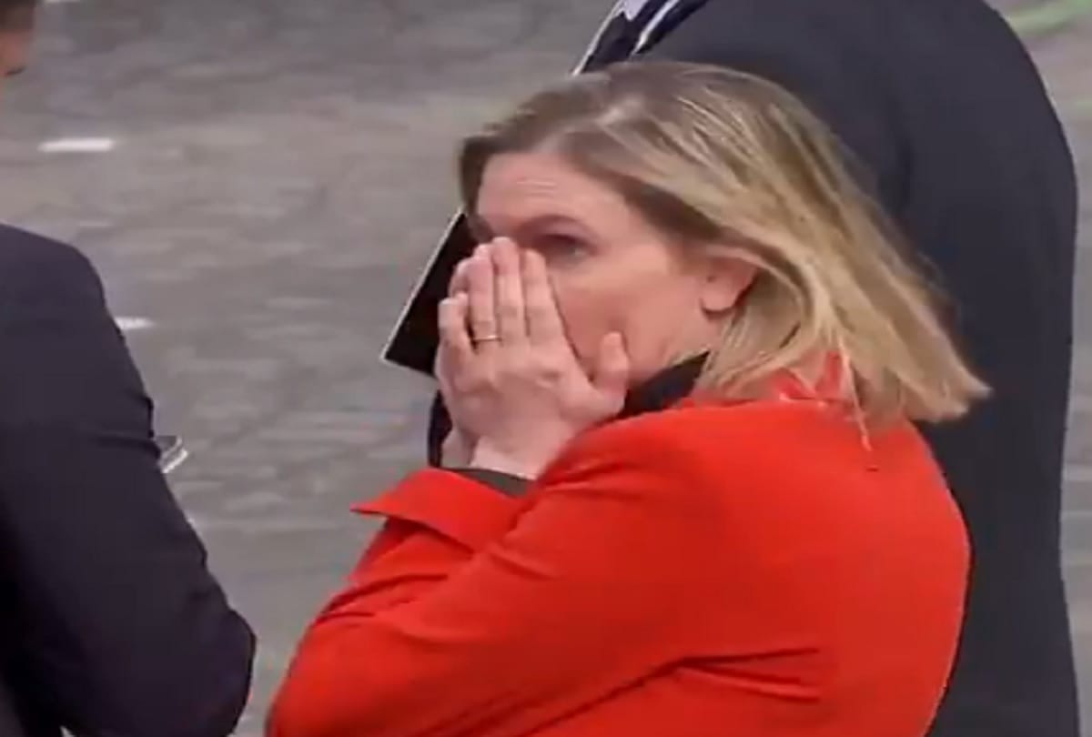 A French minister covered her face with her hands after she realized she had forgotten her mask at military day parade