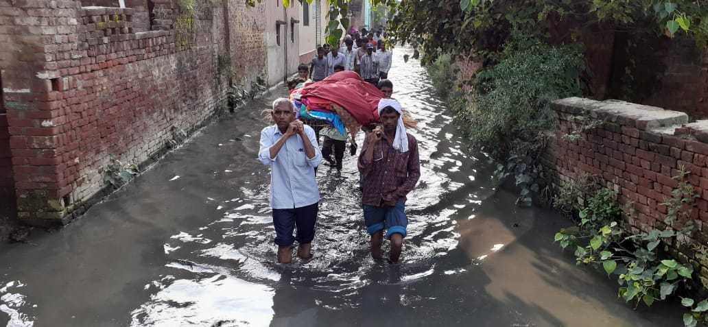 The last journey of an old woman out of the water filled to her knees