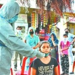 कोरोना का नमूना लेता स्वास्थ्यकर्मी