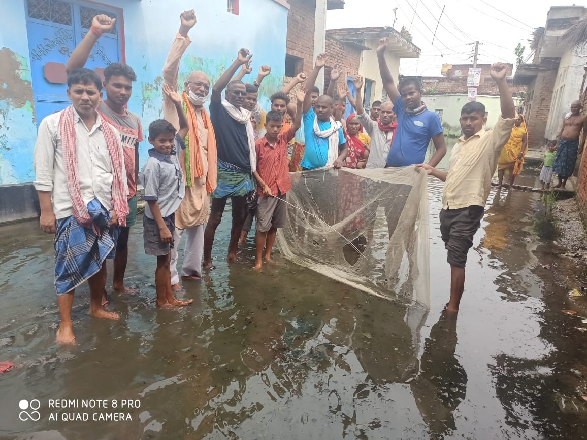 Protest by hitting fish in rainy water stored on the road