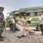 जम्मू—कश्मीर में मंगलवार को बस की चेकिंग के दौरान एक यात्री के सामान की जांच करते सुरक्षाकर्मी।