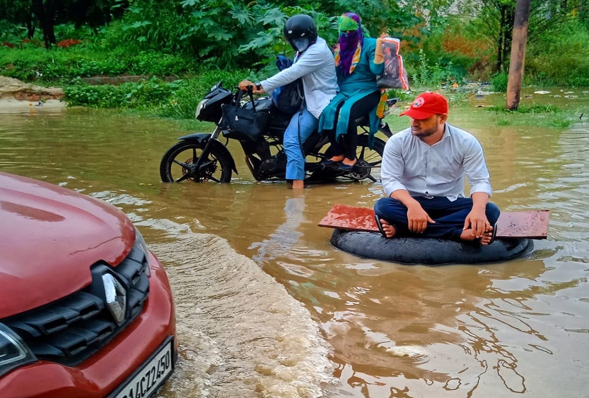 Ghaziabad rain water logging SP leader jeetu sharma seat on tyre between water logged road protest against ghaziabad municipal corporation