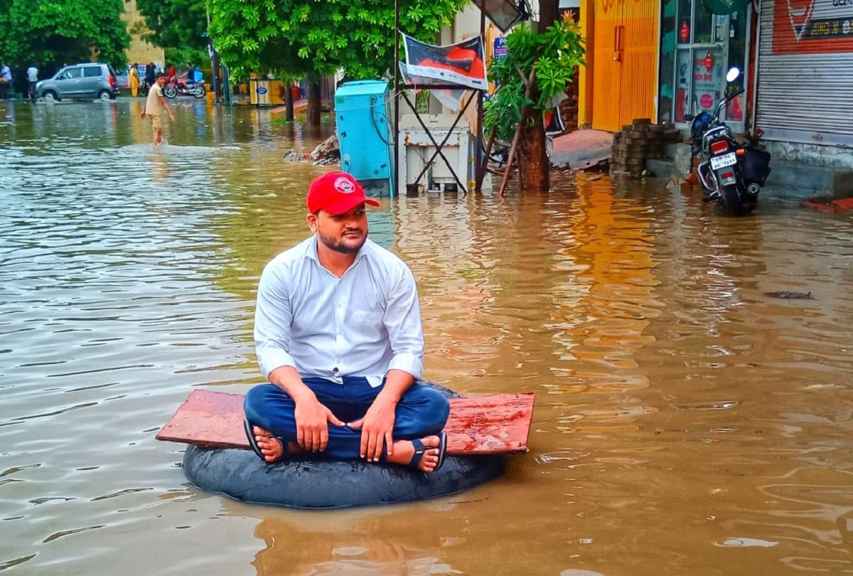 Ghaziabad rain water logging SP leader jeetu sharma seat on tyre between water logged road protest against ghaziabad municipal corporation