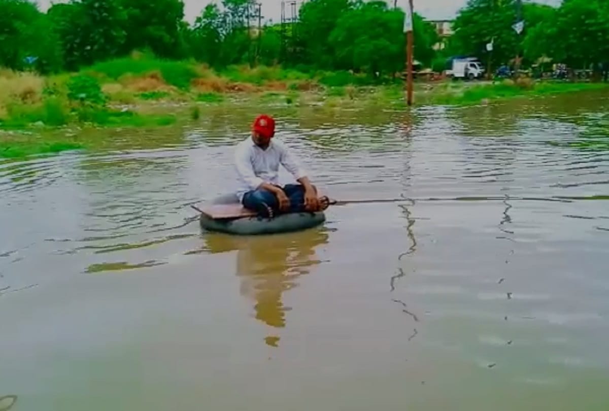 Ghaziabad rain water logging SP leader jeetu sharma seat on tyre between water logged road protest against ghaziabad municipal corporation