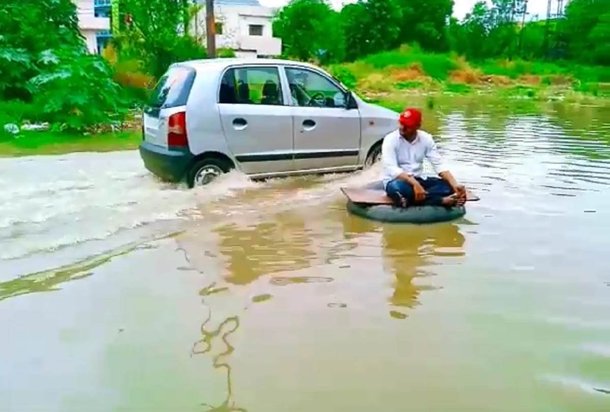 Ghaziabad rain water logging SP leader jeetu sharma seat on tyre between water logged road protest against ghaziabad municipal corporation