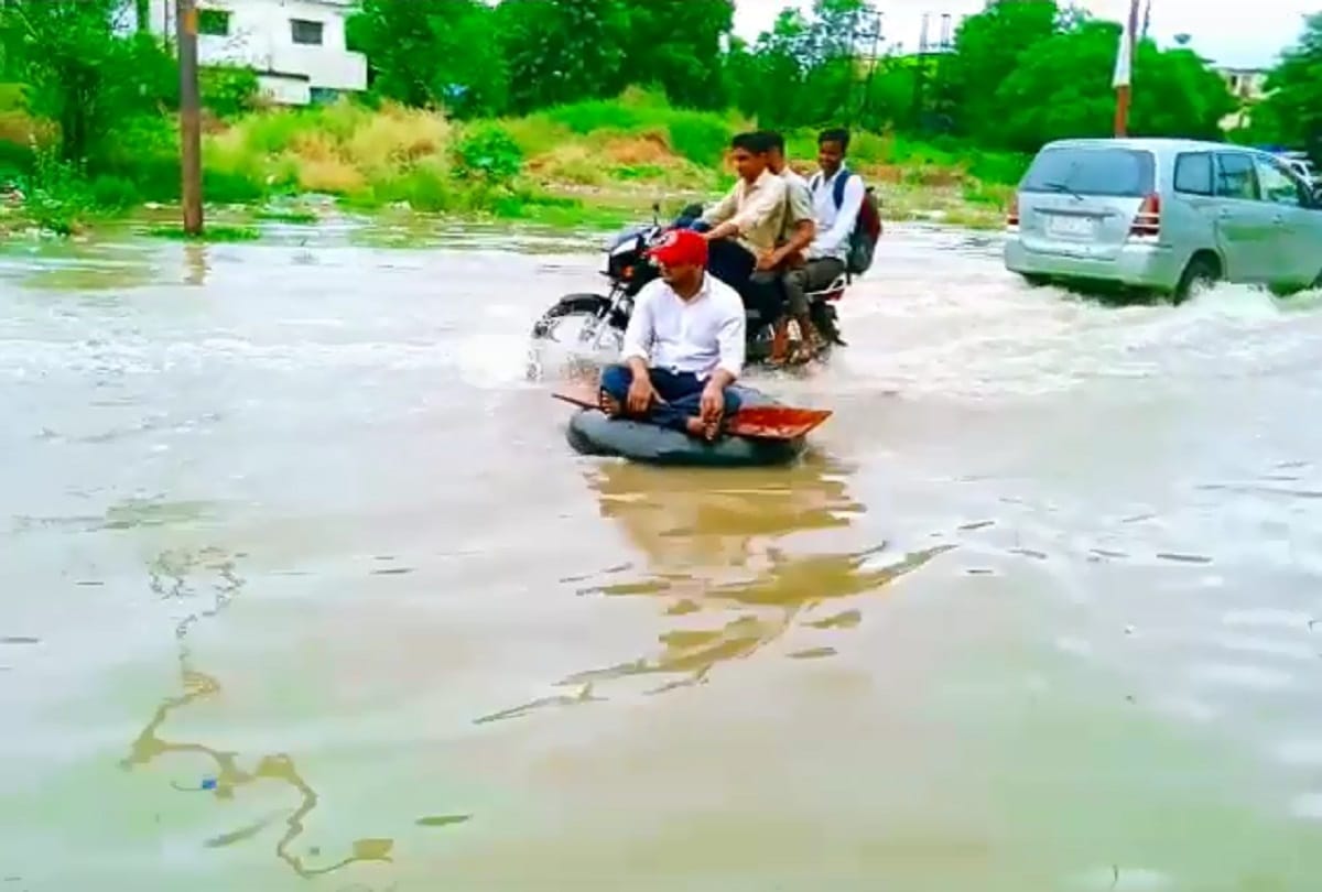 Ghaziabad rain water logging SP leader jeetu sharma seat on tyre between water logged road protest against ghaziabad municipal corporation