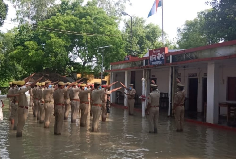 Police men hoists flag amid flood water in Bahraich.