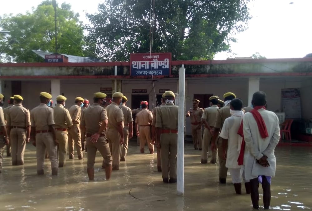 Police men hoists flag amid flood water in Bahraich.
