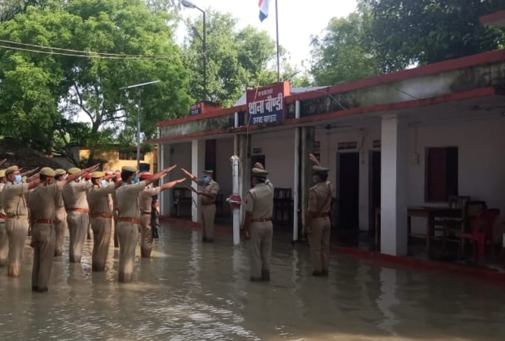 Police men hoists flag amid flood water in Bahraich.
