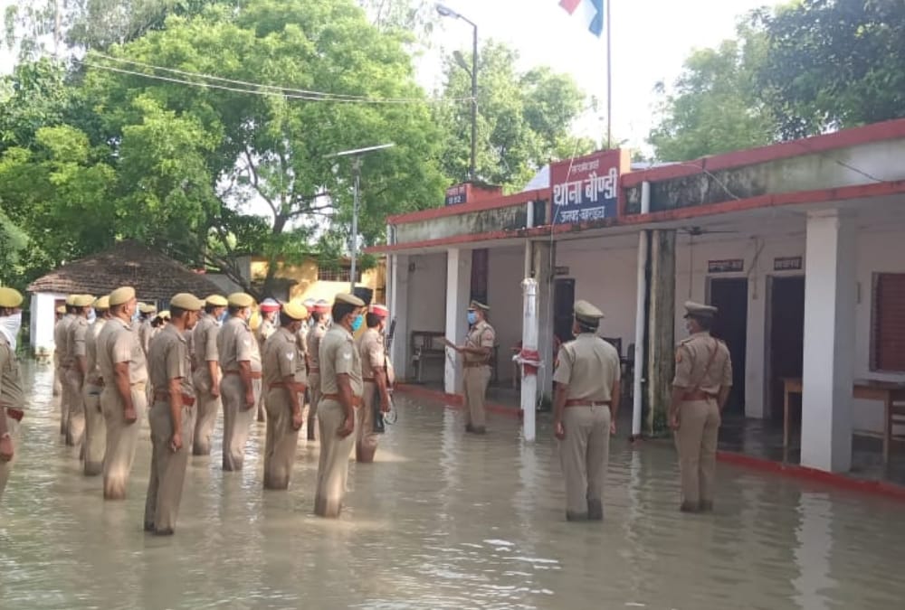 Police men hoists flag amid flood water in Bahraich.