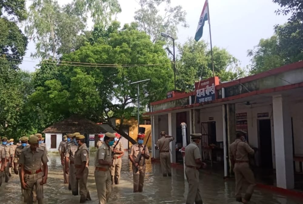Police men hoists flag amid flood water in Bahraich.