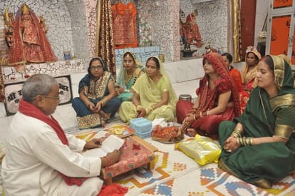 तीज पर्व के मौके हनुमान घाट मंदिर पर कथा सुनतीं व्रती महिलाएं।