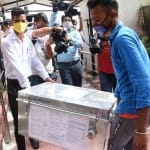 एनआईए की चार्जशीट ले जाते कर्मचारी।