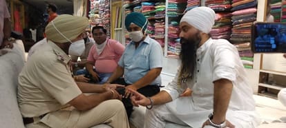 जालंधर के अटारी बाजार में खुली दुकानो को बंद करवाने के लिए दुकानदारों से बातचीत करती पुलिस।