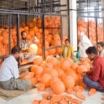 मेरठ की एक फैक्टरी में फुटबॉल के ब्लैडर तैयार करते कर्मचारी