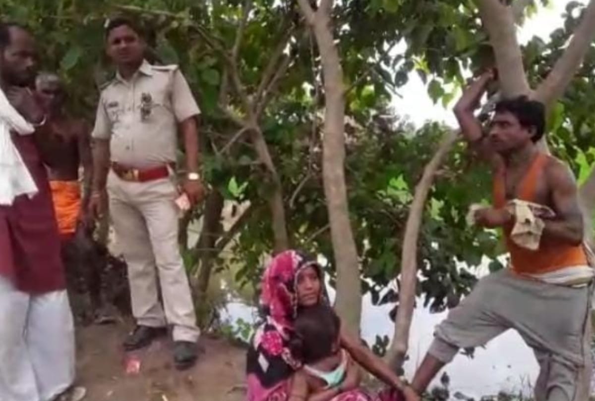 villagers beat in front of khaki tied in trees