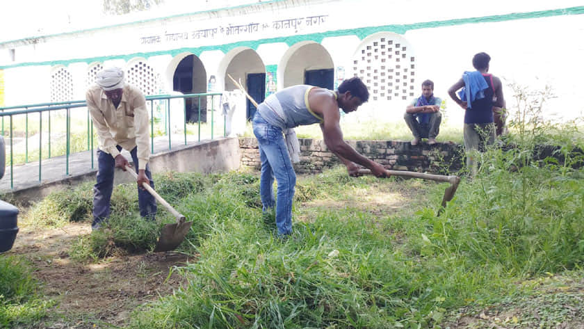 उदईपुर गांव में सरकारी स्कूल के पास सफाई करते सफाईकर्मी।