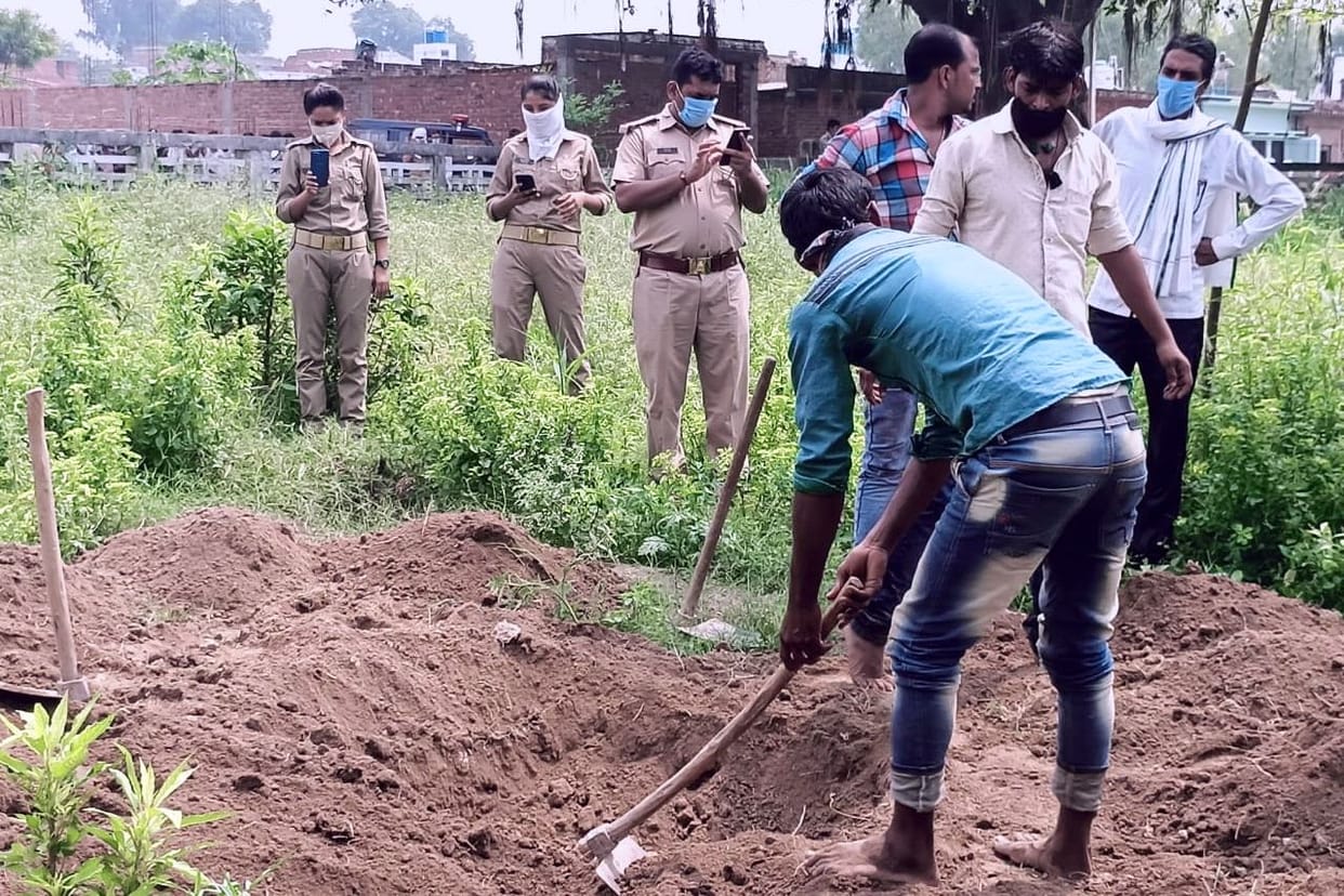police take deadbody out from grave