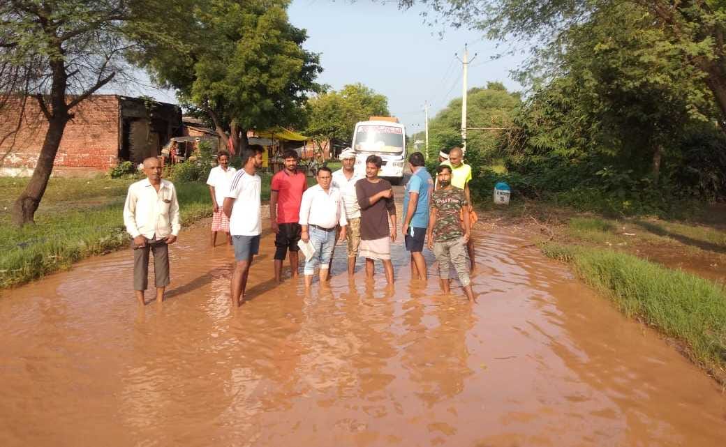 Water filled on the road, protested by standing in the pit