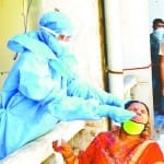कोरोना वायरसः जांच के नमूने लेते कर्मचारी