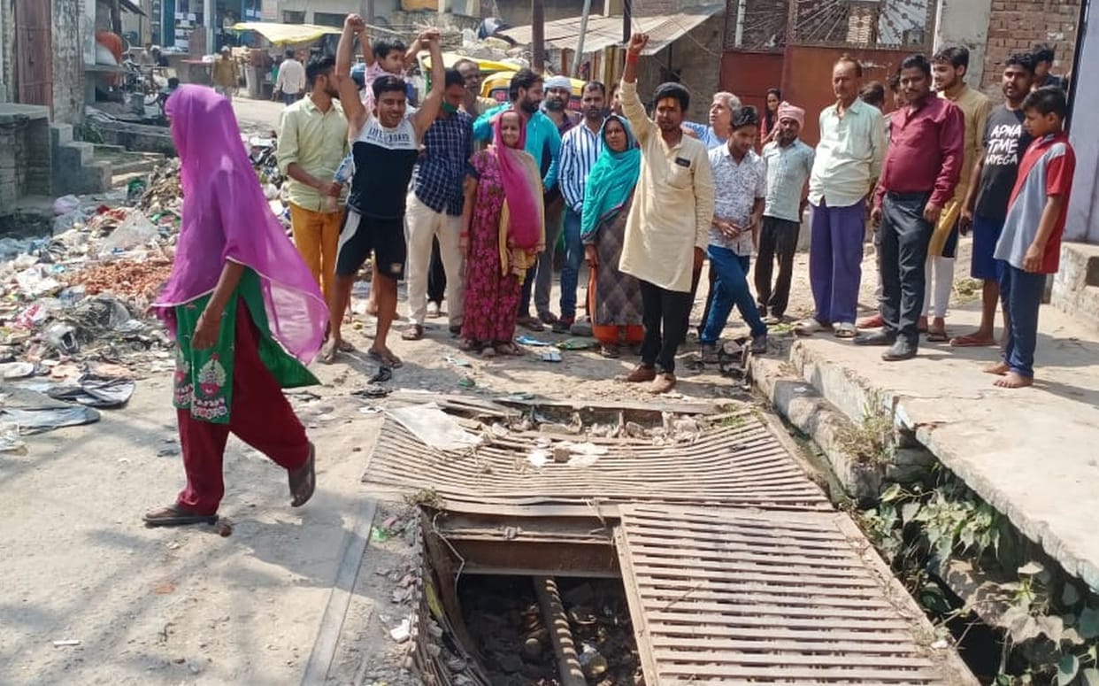 Demonstration of people troubled by broken road, open manhole