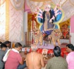 शहर में सजाये गये देवी पंडाल में मूर्ति स्थापना के दौरान पूजन करते भक्तगण