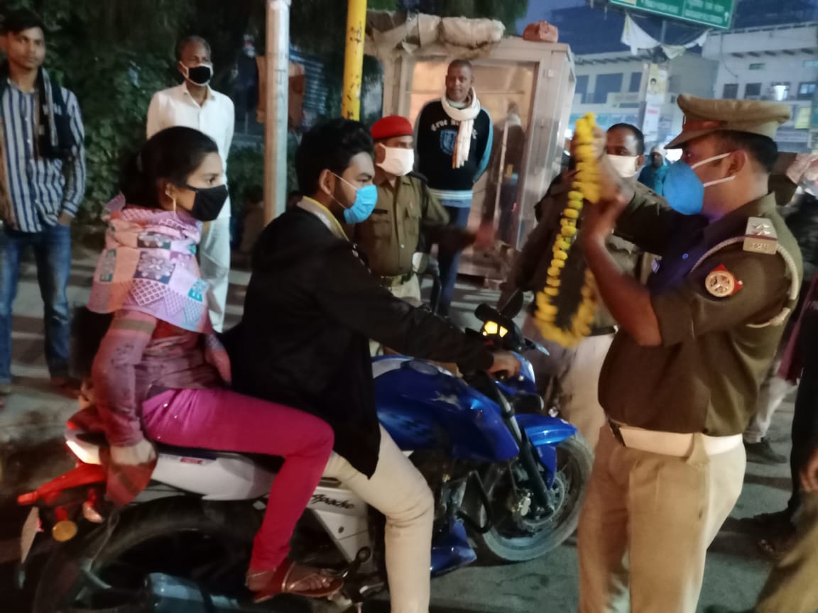 Traffic police wearing flower garland for those not wearing helmets